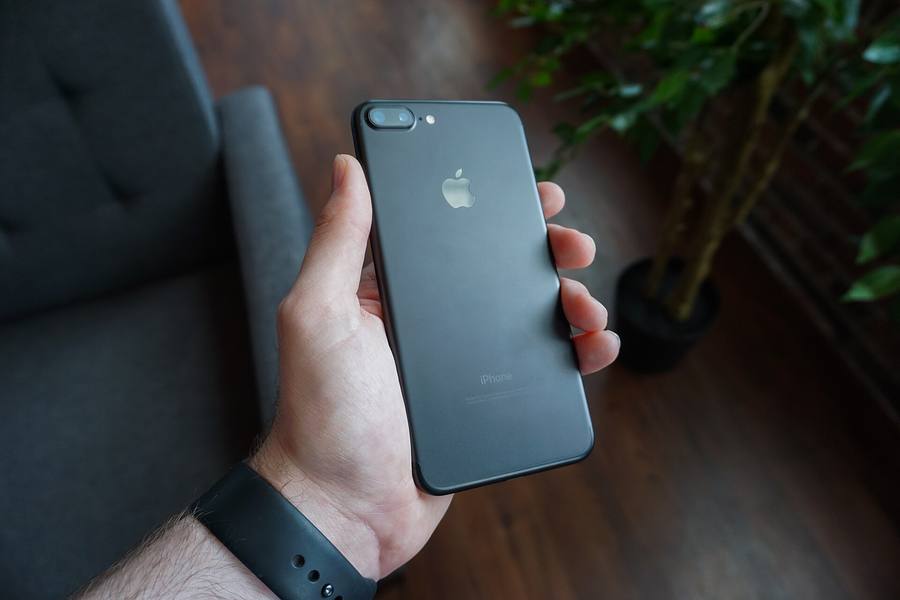Ponsel dipegang satu tangan, melambangkan membaca mobile